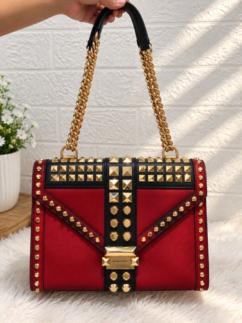 Michael Kors Red Black Studded Shoulder Bag (Category: Luxury Bags & Wallets) located in Caloocan City. Submitted by danicamae35900 (Listing ID 1469217510, Image 2). Description: - Brand: Michael Kors - Color: Bold red and black with gold-tone hardware - Design: Covered in pyramid and round studs on front flap and center stripe - Straps: Chain shoulder straps with comfortable black leather sections - Closure: Structured shape with Michael Kors st