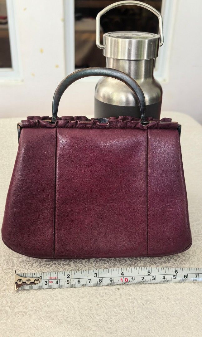 Micro kiss lock handbag (Category: Purses & Pouches) located in Tuguegarao City. Submitted by zenphoenix-7ad615 (Listing ID 1469189273, Image 3). Description: Dark purple leather micro Kisslock bag Length 7 inches CP does not fit.