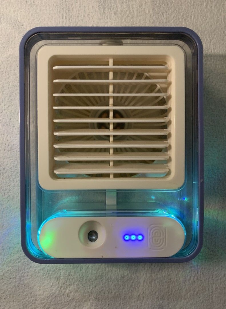 Mini Portable Air Cooler Fan with LED Lights (Category: Fans) located in Baguio. Submitted by grazia.ivy (Listing ID 1469300953, Image 1). Description: - Compact desktop air cooler, perfect for office desks or bedside tables - USB-powered for convenient plug-and-play use anywhere - Features adjustable louvers to direct airflow where you need it - Built-in colorful LED lighting inside the transparent water tank - Easy-to-use front panel with power