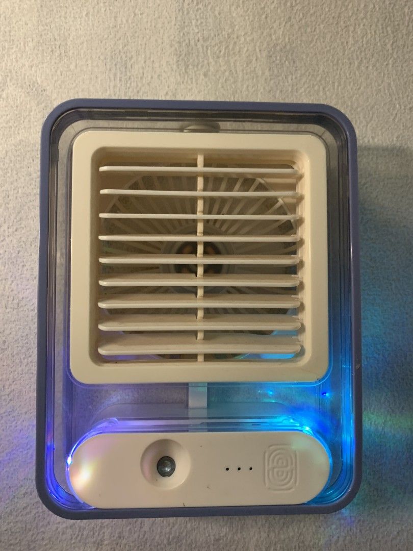 Mini Portable Air Cooler Fan with LED Lights (Category: Fans) located in Baguio. Submitted by grazia.ivy (Listing ID 1469300953, Image 2). Description: - Compact desktop air cooler, perfect for office desks or bedside tables - USB-powered for convenient plug-and-play use anywhere - Features adjustable louvers to direct airflow where you need it - Built-in colorful LED lighting inside the transparent water tank - Easy-to-use front panel with power
