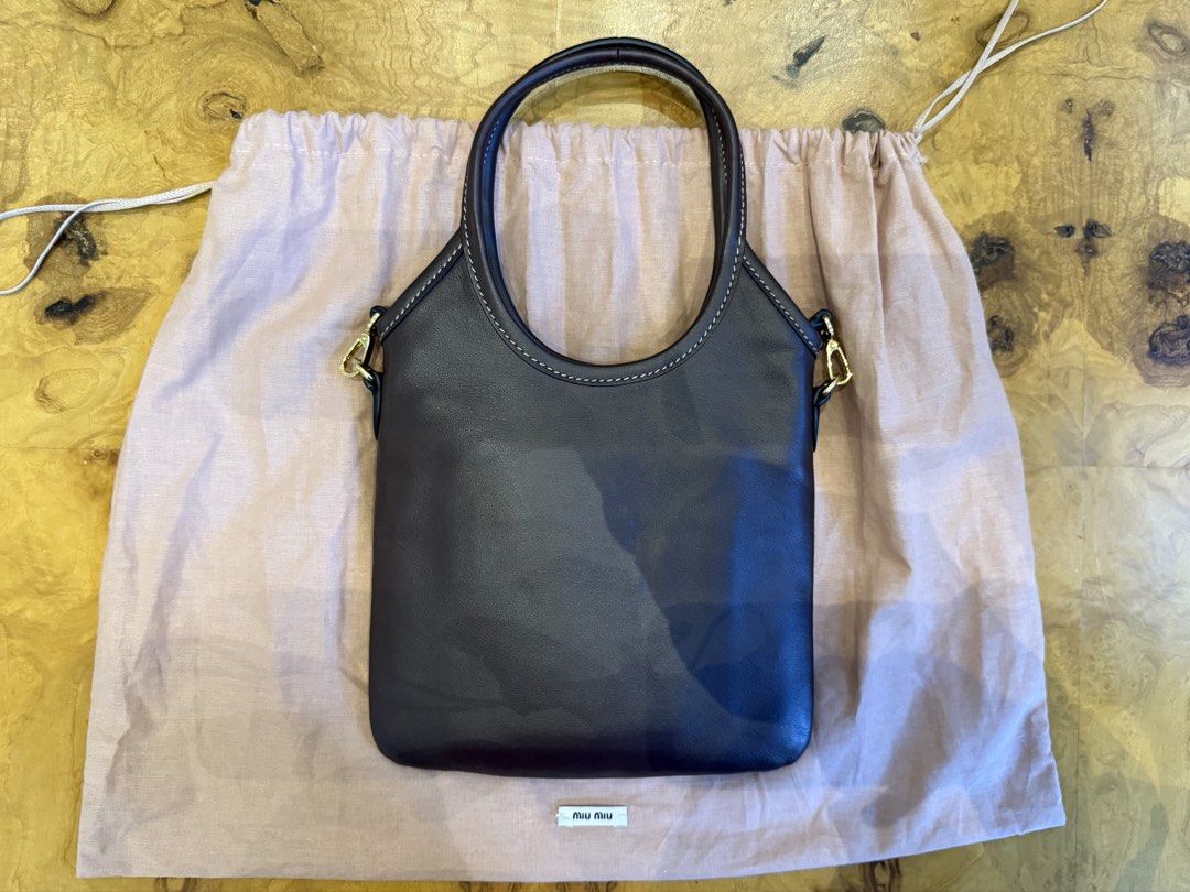 Miu Miu Dark Brown Leather Bag (Category: Luxury Bags & Wallets) located in Manila. Submitted by moscloset (Listing ID 1469231616, Image 2). Description: BRAND NEW AUTHENTIC MIU MIU MINI IVY TOTE BAG Current Market Price: ₱100,000 Condition: Excellent (10/10) Reason for Selling: Never used Additional Details: Color: Chocolate Brown Flaws: None Inclusions: Dust bag, crossbody strap.