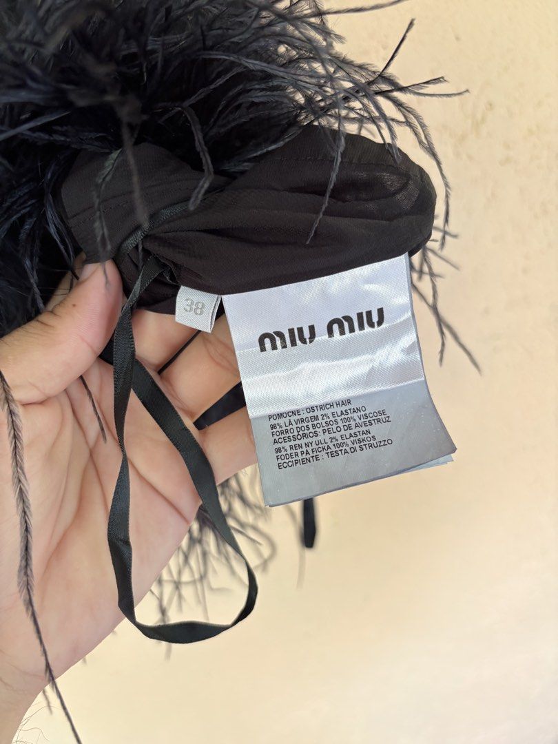 Miu Miu Stretch Cady Halter Top with Feathers (Category: Sleeveless) located in Pozorrubio. Submitted by zionegotthrift (Listing ID 1469199230, Image 3). Description: - Brand: Miu Miu - Style: Stretch cady halter top with tie closure - Color: Black - Size: 38 (PH S/M) - Material: Virgin wool and elastane - Special Detail: Genuine ostrich feather trim along the hem - Inclusions: Original designer label and composition tags attached.