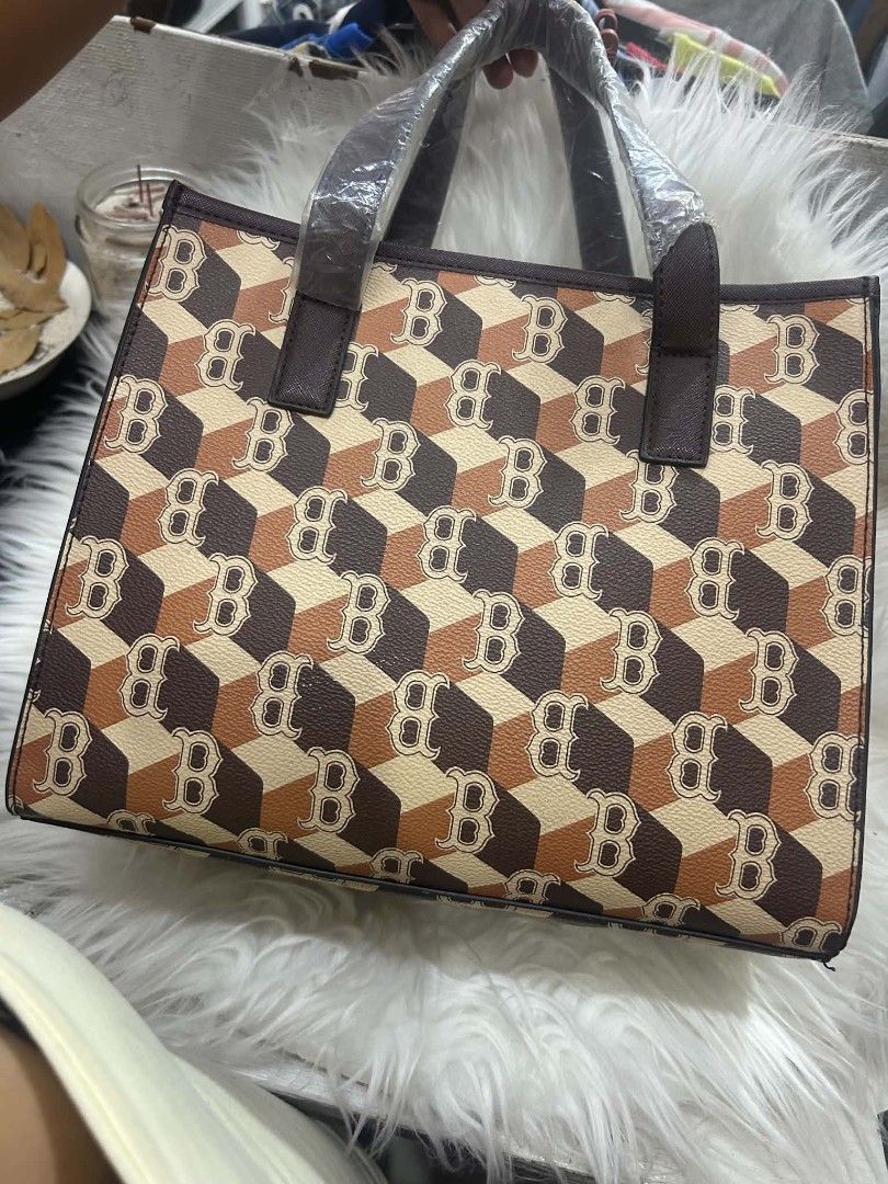 MLB Brown Monogram Tote Bag with Strap (Category: Tote Bags) located in Manila. Submitted by kkiato (Listing ID 1469283568, Image 3). Description: - Stylish brown and beige MLB monogram cube print tote bag - Dual top handles wrapped in protective plastic for safekeeping - Includes a detachable matching shoulder strap for versatile wear - Main interior compartment equipped with a secure zipper side pocket - Clean interior lining with original bran