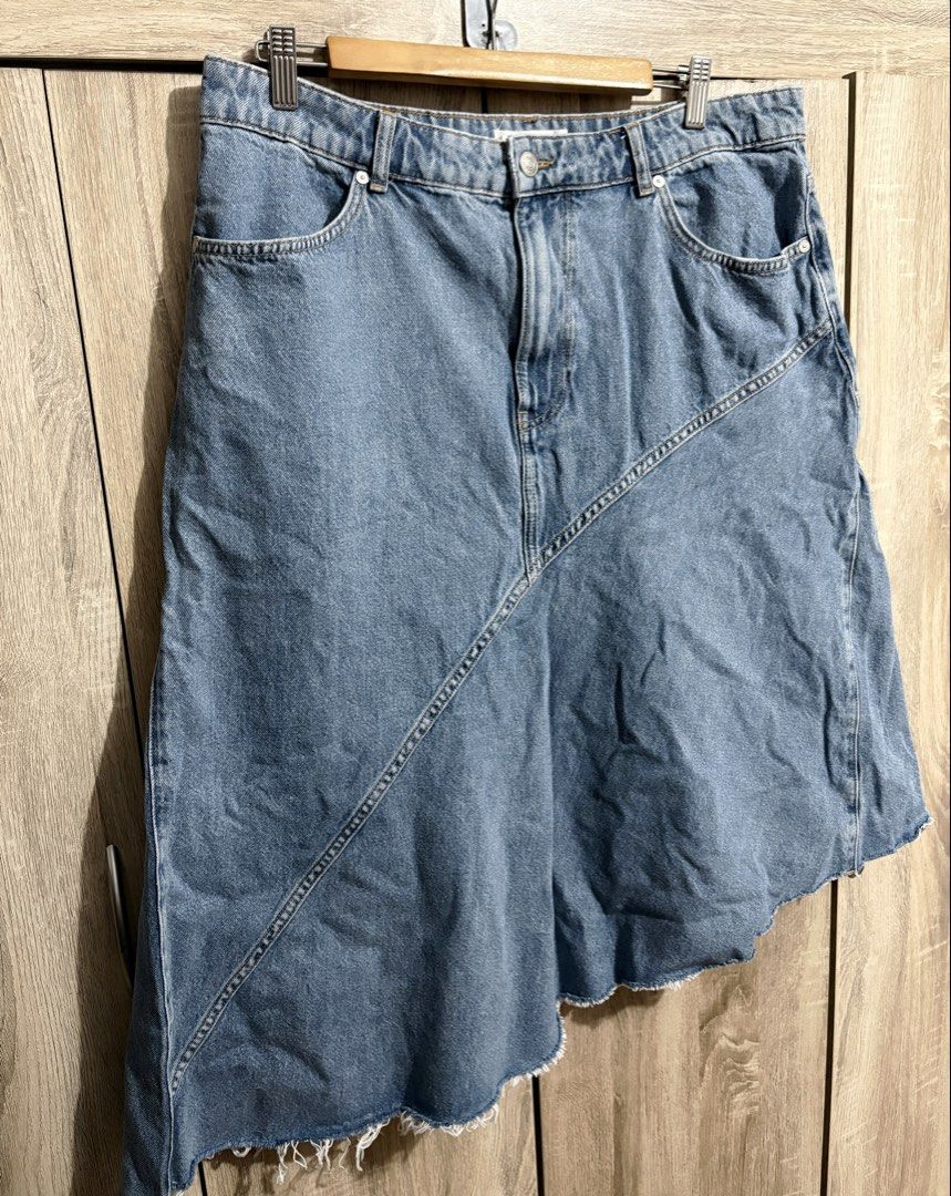 MNG Plus Size Denim Asymmetrical Hem Skirt (Category: Skirts) located in Manila. Submitted by topsh0ppe (Listing ID 1469216497, Image 2). Description: - Brand: Mango - Size: XL - Color: Light blue wash - Material: 100% cotton, made in Turkey - Design: Asymmetrical hem with raw frayed edges, diagonal front and back seams - Closure: Button and zipper fly with belt loops - Pockets: Two front pockets, two back patch pockets Waist up to 38in (high wai