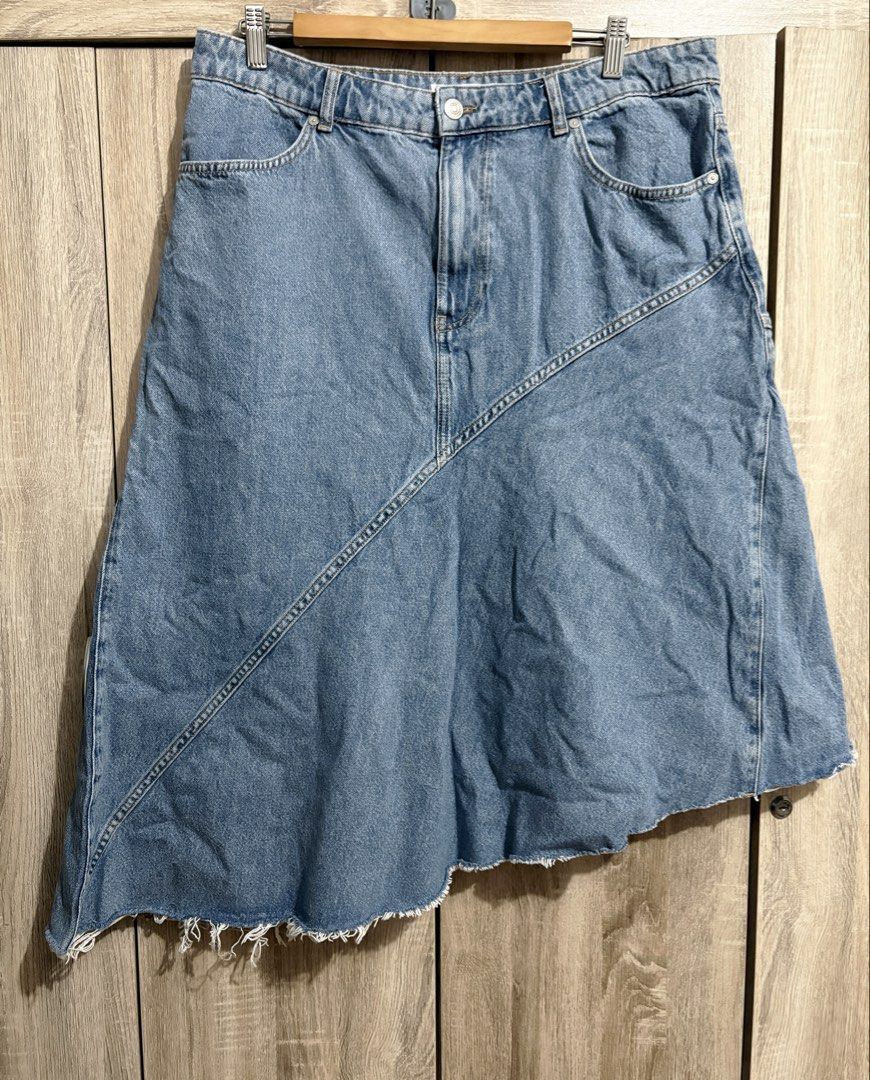 MNG Plus Size Denim Asymmetrical Hem Skirt (Category: Skirts) located in Manila. Submitted by topsh0ppe (Listing ID 1469216497, Image 1). Description: - Brand: Mango - Size: XL - Color: Light blue wash - Material: 100% cotton, made in Turkey - Design: Asymmetrical hem with raw frayed edges, diagonal front and back seams - Closure: Button and zipper fly with belt loops - Pockets: Two front pockets, two back patch pockets Waist up to 38in (high wai