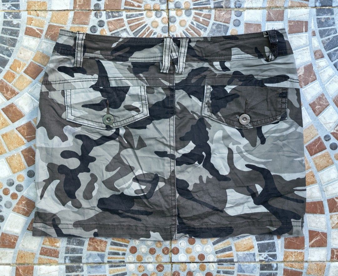 MXE Camouflage Mini Skirt Size 27 (Category: Skirts) located in Quezon. Submitted by miksxthrift (Listing ID 1469276541, Image 2). Description: - Brand: MXE - Style: Camouflage utility mini skirt with street style vibe - Size: 27 waist - Colorway: Green, brown, and grey tones - Details: Front pockets, buttoned back flap pockets, red skull patch on the front right, and belt loops - Closure: Front button closure - Material: Comfortable cotton blend