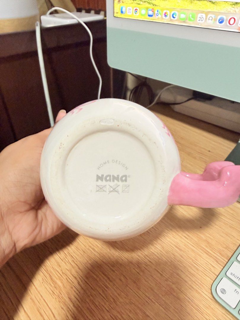 Nana Home Design ceramic pink bow mug (Category: Coffee & Tea Tableware) located in Manila. Submitted by badassjowie (Listing ID 1469368435, Image 2). Description: - Adorable white ceramic mug with all-over pink bow pattern - Unique handle shaped like a cute pink bow with matching pink rim detail - Authentic Nana Home Design stamp on the bottom - Features microwave and dishwasher safe symbols underneath - Generous size, ideal for your morning cof