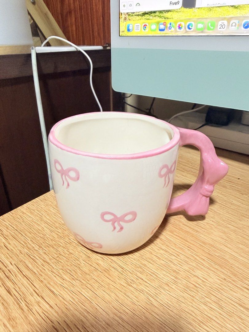 Nana Home Design ceramic pink bow mug (Category: Coffee & Tea Tableware) located in Manila. Submitted by badassjowie (Listing ID 1469368435, Image 1). Description: - Adorable white ceramic mug with all-over pink bow pattern - Unique handle shaped like a cute pink bow with matching pink rim detail - Authentic Nana Home Design stamp on the bottom - Features microwave and dishwasher safe symbols underneath - Generous size, ideal for your morning cof