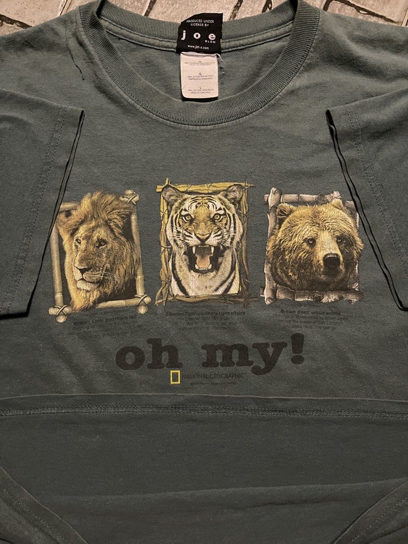 National geographic Shirt (Category: Tshirts & Polo Shirts ) located in Baguio. Submitted by ezrab. (Listing ID 1469313513, Image 1). Description: - Color: Green - Material: Cotton - Size: Large (Relaxed fit, crew neck) - Graphic: Lion, tiger, and bear print with 'oh my!' text (minor cracking due to age) - Manufactured in Honduras under license by Joe Blow.