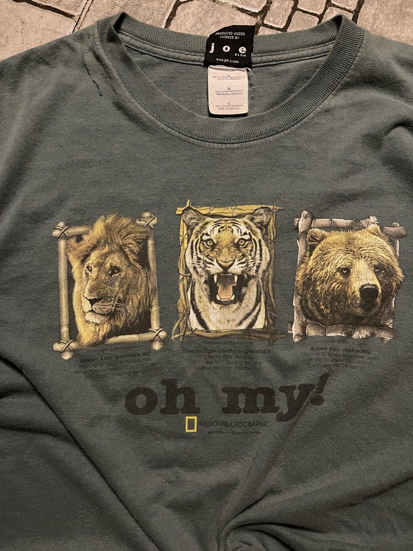 National geographic Shirt (Category: Tshirts & Polo Shirts ) located in Baguio. Submitted by ezrab. (Listing ID 1469313513, Image 3). Description: - Color: Green - Material: Cotton - Size: Large (Relaxed fit, crew neck) - Graphic: Lion, tiger, and bear print with 'oh my!' text (minor cracking due to age) - Manufactured in Honduras under license by Joe Blow.