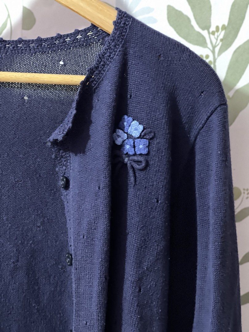 Navy Cardigan fit small frame size 140 (Category: Coats, Jackets and Outerwear) located in Pasig City. Submitted by morilove (Listing ID 1469183204, Image 3). Description: - Brand: Familiar - Size: 140 - Color: Navy blue - Design: Button-down front with dark buttons, delicate lace trim on neckline and hem - Special Detail: Cute blue flower appliqué with ribbon stems on the chest - Material: Soft knit with subtle textured dots - Condition: Excelle