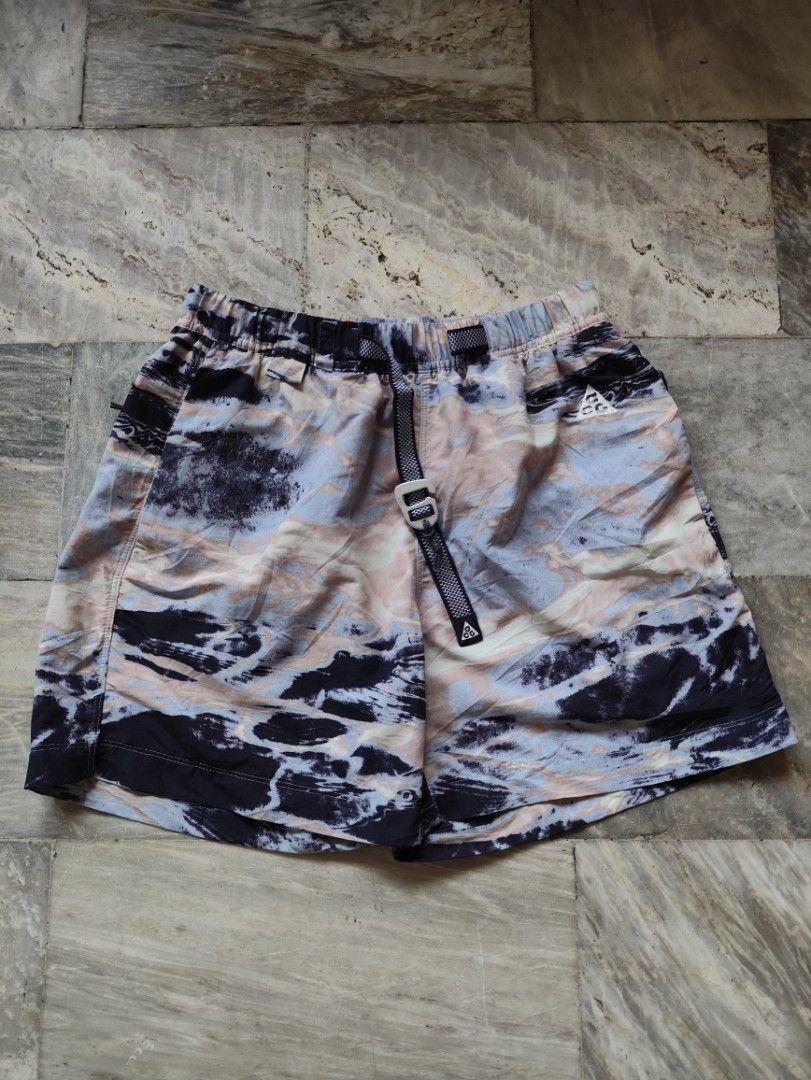 Nike ACG Trail Short FB4198-601 (Category: Shorts) located in Manila. Submitted by glenndejes07057 (Listing ID 1469299909, Image 1). Description: - Brand: Nike ACG - Size: XS - Colorway: Multi-color marble tie-dye (Blue, Pink, Dark Navy) - Material: 100% Nylon body, Polyester pocket bags - Features: Built-in adjustable webbed belt with buckle, comfortable elastic waistband, and secure zip pockets - Origin: Made in Indonesia - Perfect for: Hiking,