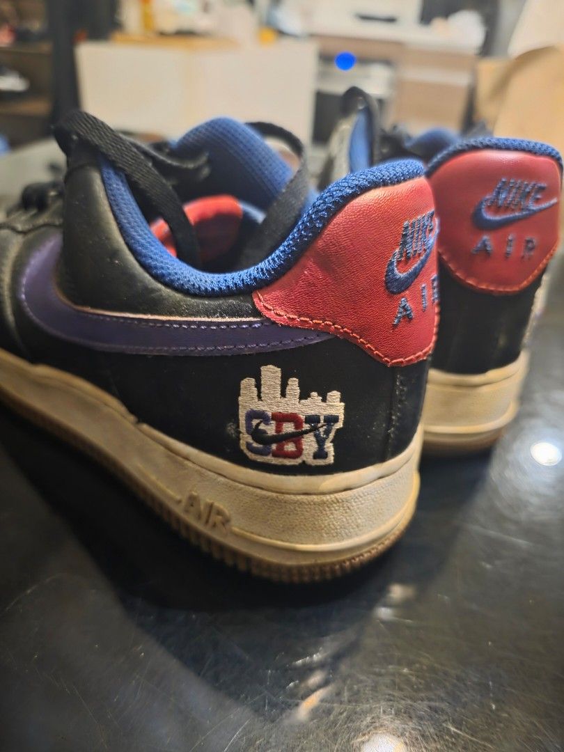 Nike Air Force 1 Low City Edition (Category: Sneakers) located in Manila. Submitted by collectndeclutt (Listing ID 1469302764, Image 1). Description: - Brand: Nike Air Force 1 - Color/Material: Black leather upper with purple side swoosh - Accents: Blue inner lining, bright red heel tabs, and blue embroidered Nike Air branding - Special Detail: Embroidered NYC city skyline graphic with NYC lettering on the lateral heel - Condition: White midsoles