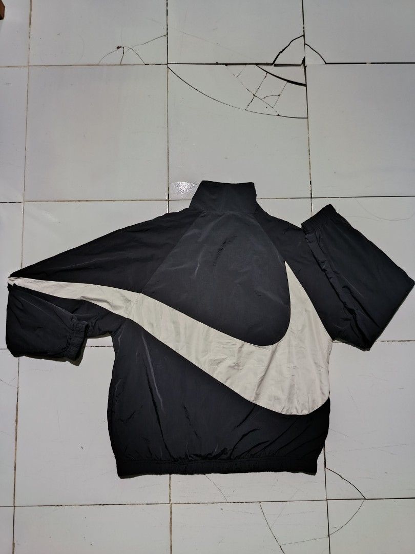 Nike Big Swoosh Black White Windbreaker Jacket (Category: Coats, Jackets and Outerwear) located in Barotac Nuevo. Submitted by gray101 (Listing ID 1469291324, Image 2). Description: - Brand: Nike - Style: Black and white windbreaker with large wrap-around Swoosh design - Size: Large (tag attached) - Material: Durable nylon body with breathable mesh lining - Hardware: Smooth full-zip closure with YKK zippers - Origin: Made in Vietnam - Condition: 