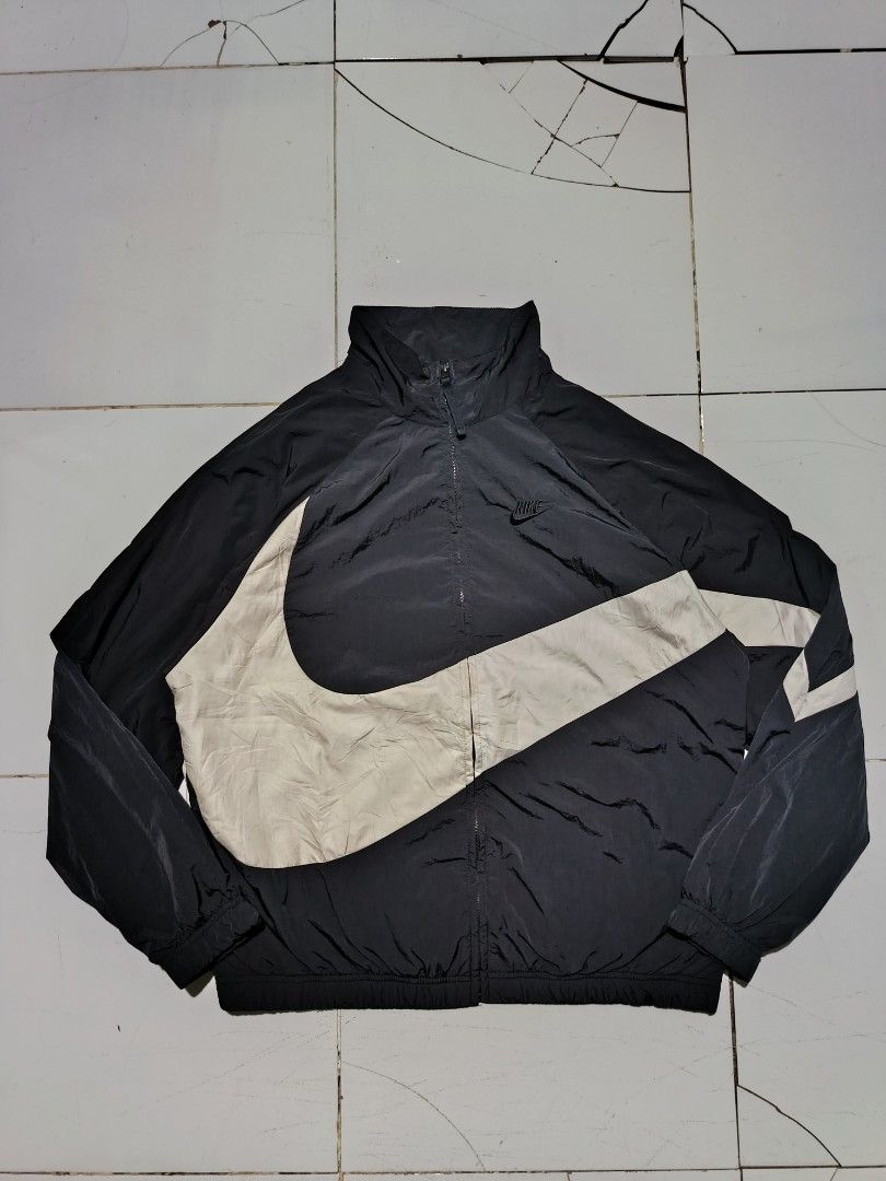 Nike Big Swoosh Black White Windbreaker Jacket (Category: Coats, Jackets and Outerwear) located in Barotac Nuevo. Submitted by gray101 (Listing ID 1469291324, Image 1). Description: - Brand: Nike - Style: Black and white windbreaker with large wrap-around Swoosh design - Size: Large (tag attached) - Material: Durable nylon body with breathable mesh lining - Hardware: Smooth full-zip closure with YKK zippers - Origin: Made in Vietnam - Condition: 