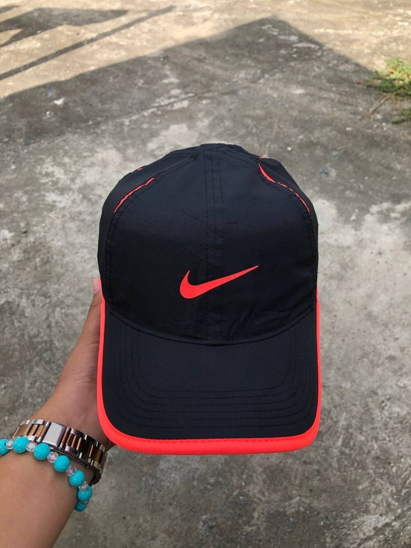Nike Featherlight Dri-FIT Black and Red Cap (Category: Caps & Hats) located in Manila. Submitted by jowiegarci63146 (Listing ID 1469311504, Image 1). Description: - Authentic Nike Featherlight Dri-FIT cap in sleek black with bright red trim - Iconic embroidered red Swoosh on the front - Lightweight, breathable material ideal for running and gym workouts - Adjustable velcro strap in the back with Nike logo tag for a custom fit - Dri-FIT technology