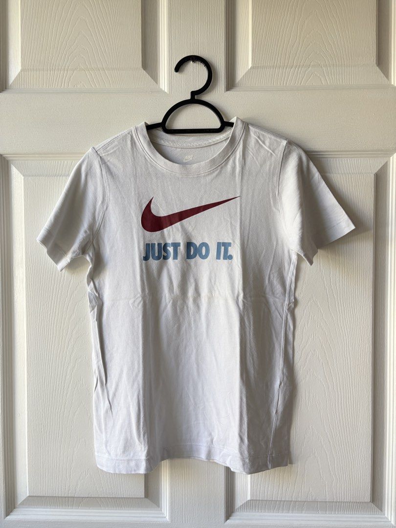 Nike Just Do It T-Shirt (Category: Babies & Kids Fashion) located in Liloan. Submitted by mrs.jboiser (Listing ID 1469226041, Image 1). Description: - Brand: Nike - Color: White with maroon swoosh and light blue 'JUST DO IT' text - Fit: Standard fit, short sleeves, crew neck - Style: Casual everyday tee - Shipping & Meet-ups: DM for details / Fast shipping available.