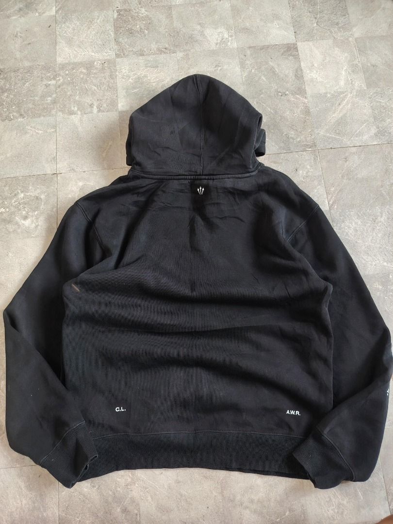 Nike NOCTA Black Hoodie (Category: Coats, Jackets and Outerwear) located in Dasmarinas. Submitted by clydegallo40531 (Listing ID 1469187193, Image 2). Description: - Authentic Black Nike NOCTA Hoodie - Color: Black with white branding - White Nike swoosh logo below neckline with small text - NOCTA branding printed down the right sleeve - Small trident graphic on the lower left sleeve - Functional front kangaroo pocket - Adjustable drawstrings on 