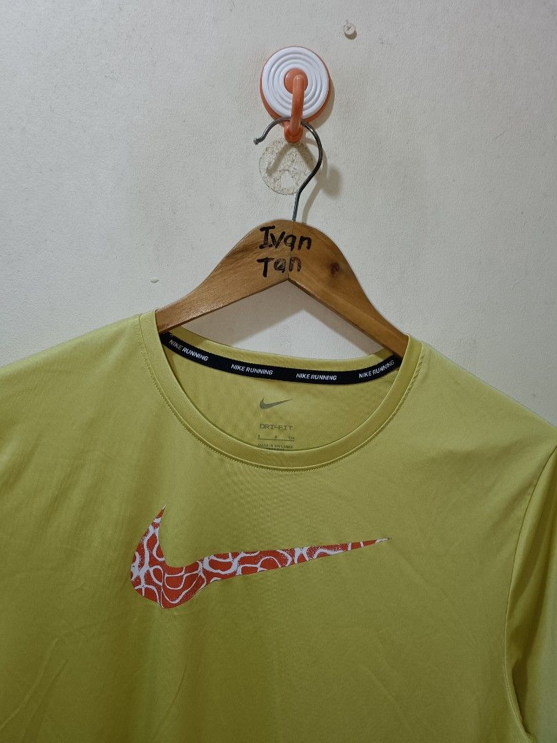 Nike Running Shirt (Category: Activewear) located in Makati City. Submitted by ivsseyow03 (Listing ID 1469278930, Image 2). Description: Yellow-green Nike running t-shirt in size small. Features a patterned red and white swoosh logo across the chest. Nike Running text taping along the inner collar. Dri-fit material keeps you cool and dry. Lightweight fabric with short sleeves. Style code DM4816-304 printed on the inner tag..