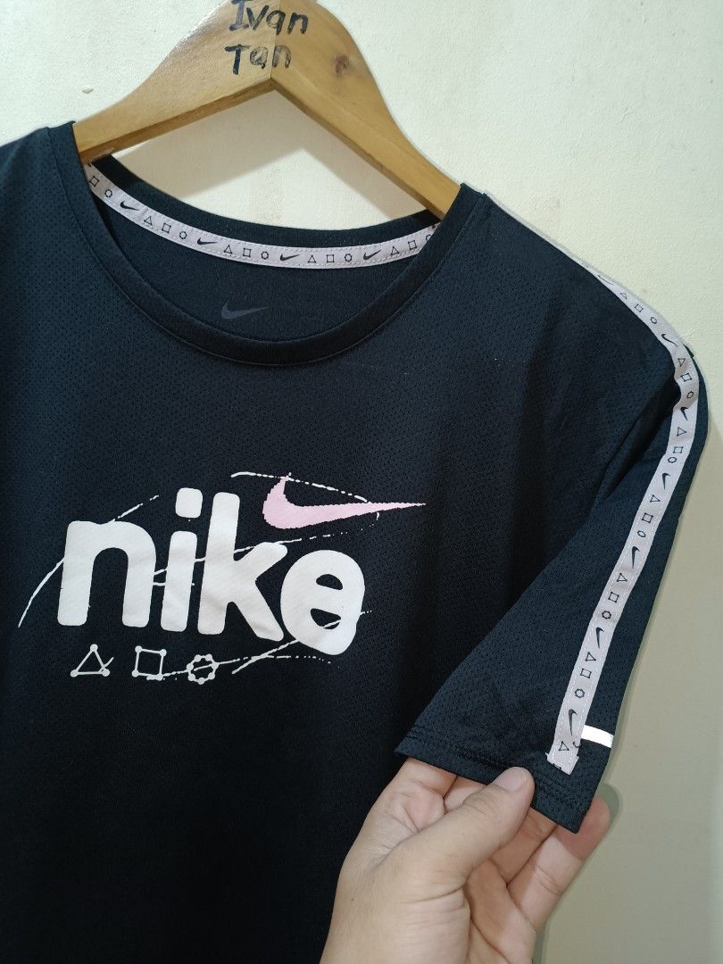 Nike Running Shirt (Category: Tshirts & Polo Shirts ) located in Makati City. Submitted by ivsseyow03 (Listing ID 1469278953, Image 2). Description: Black Nike t-shirt with PlayStation crossover graphics on the chest and shoulder taping. Classic crew neck style. Size large tag attached in the collar. Style code DQ4735-010. Clean fabric with bright white and pink prints..