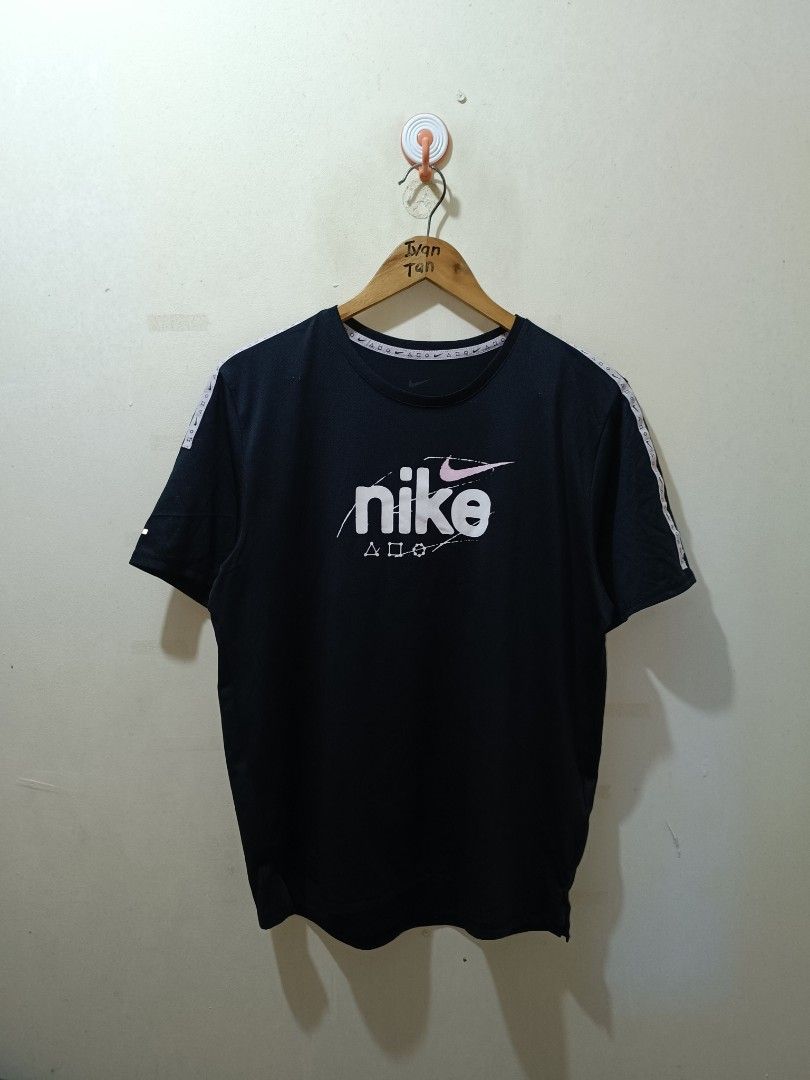 Nike Running Shirt (Category: Tshirts & Polo Shirts ) located in Makati City. Submitted by ivsseyow03 (Listing ID 1469278953, Image 1). Description: Black Nike t-shirt with PlayStation crossover graphics on the chest and shoulder taping. Classic crew neck style. Size large tag attached in the collar. Style code DQ4735-010. Clean fabric with bright white and pink prints..