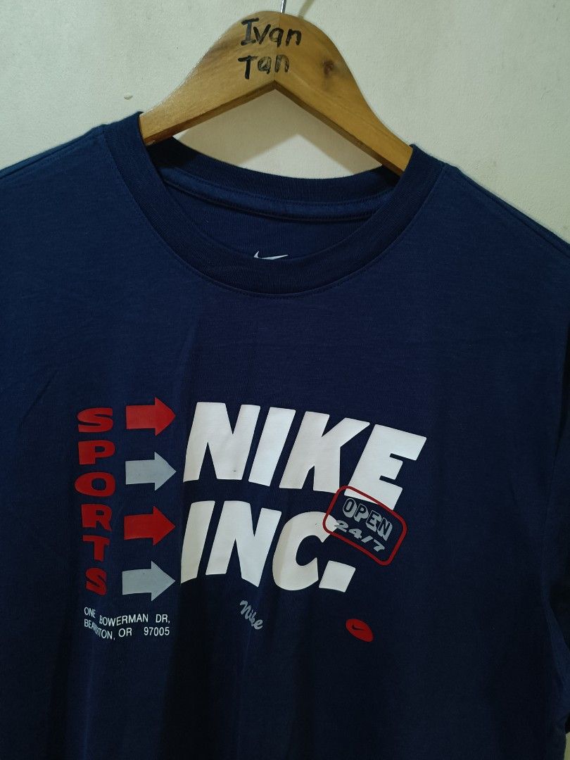 Nike Sports Shirt (Category: Tshirts & Polo Shirts ) located in Makati City. Submitted by ivsseyow03 (Listing ID 1469278931, Image 2). Description: Navy blue Nike t-shirt with graphic print on the front. Says Nike Inc and Sports with arrow accents. Includes Nike address detail on the lower left chest. Size large label on the inner tag. Style code FV8361-451. Clean condition overall..