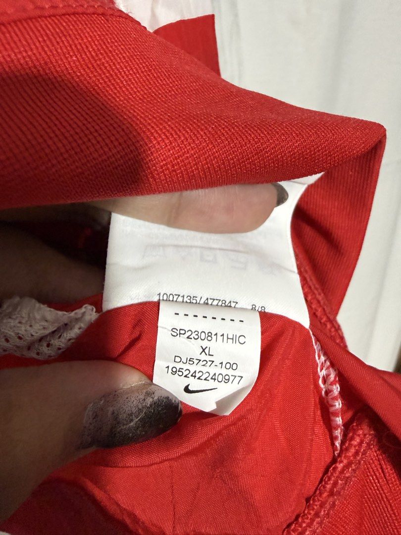 Nike Windbreaker Jacket White Red Black Size XL (Category: Coats, Jackets and Outerwear) located in Quezon City. Submitted by dapanaaaay (Listing ID 1469347994, Image 3). Description: - Brand: Nike (Style Code: DJ5727-100) - Size: XL - Color: White, Red, and Black - Design: Iconic Big Swoosh logo across the chest - Features: Half-zip neck with hood, front kangaroo pocket with zippered section, ribbed cuffs and hem - Material: Lightweight fabric w