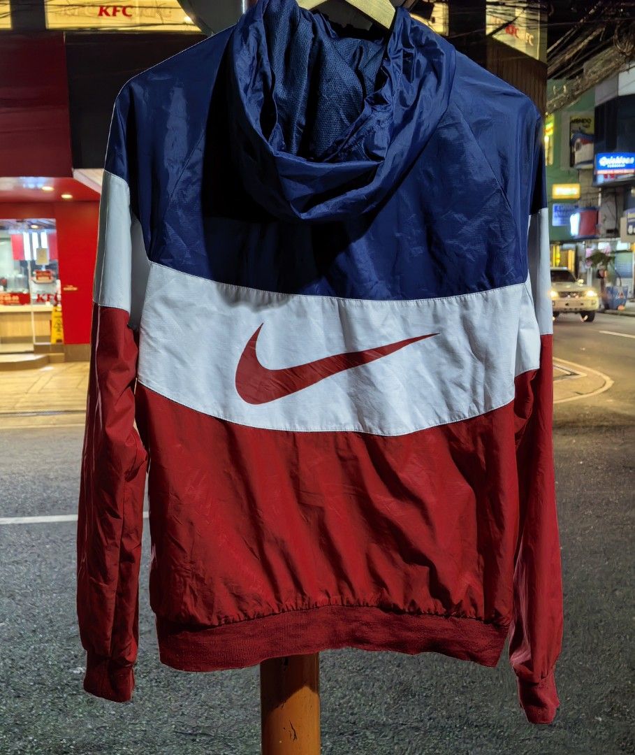 Nike Windrunner Hooded Jacket Red White Blue Size M (Category: Coats, Jackets and Outerwear) located in Quezon. Submitted by miksxthrift (Listing ID 1469313411, Image 2). Description: - Brand: Nike - Style: Windrunner jacket with hood and full zip closure - Colorway: Red, white, and blue colorblock - Size: Tagged M (Fits chest 95cm, height 165-175cm) - Material: 100% nylon body with breathable polyester mesh lining - Features: Front zip pockets, 