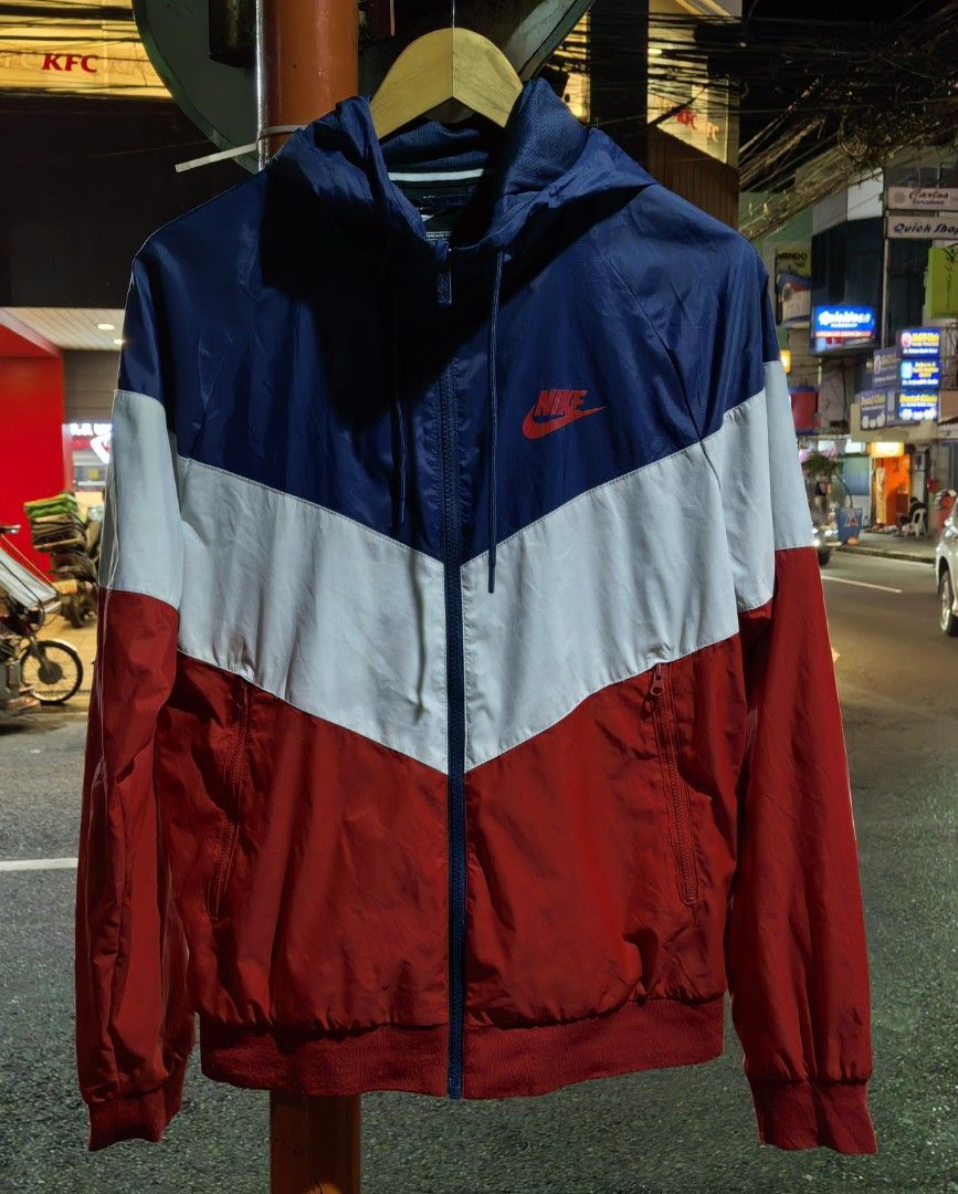 Nike Windrunner Hooded Jacket Red White Blue Size M (Category: Coats, Jackets and Outerwear) located in Quezon. Submitted by miksxthrift (Listing ID 1469313411, Image 1). Description: - Brand: Nike - Style: Windrunner jacket with hood and full zip closure - Colorway: Red, white, and blue colorblock - Size: Tagged M (Fits chest 95cm, height 165-175cm) - Material: 100% nylon body with breathable polyester mesh lining - Features: Front zip pockets, 