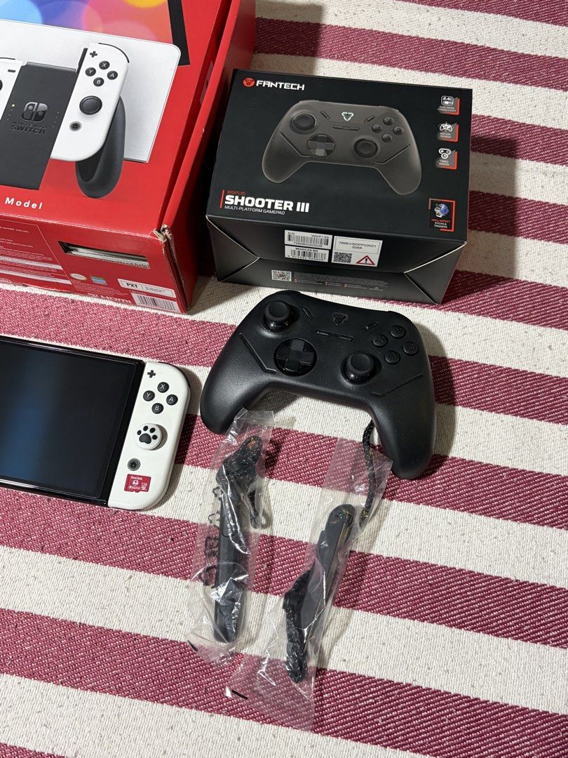 Nintendo Switch OLED Model White with Fantech Controller & Case (Category: Nintendo) located in Manila. Submitted by mr.muscleqo (Listing ID 1469365213, Image 2). Description: Nintendo Switch Oled Compelete inclusion - Original Box - Original Joycon - Joycon Wrist strap - Nintendo Switch dock - HDMI Cable - Nintendo Switch Charging adapter ACCESORIES: - Nintendo Switch bag - Tempered Glass - Fantech shooter 3 controller - 128gb Sd Card Taguig loc