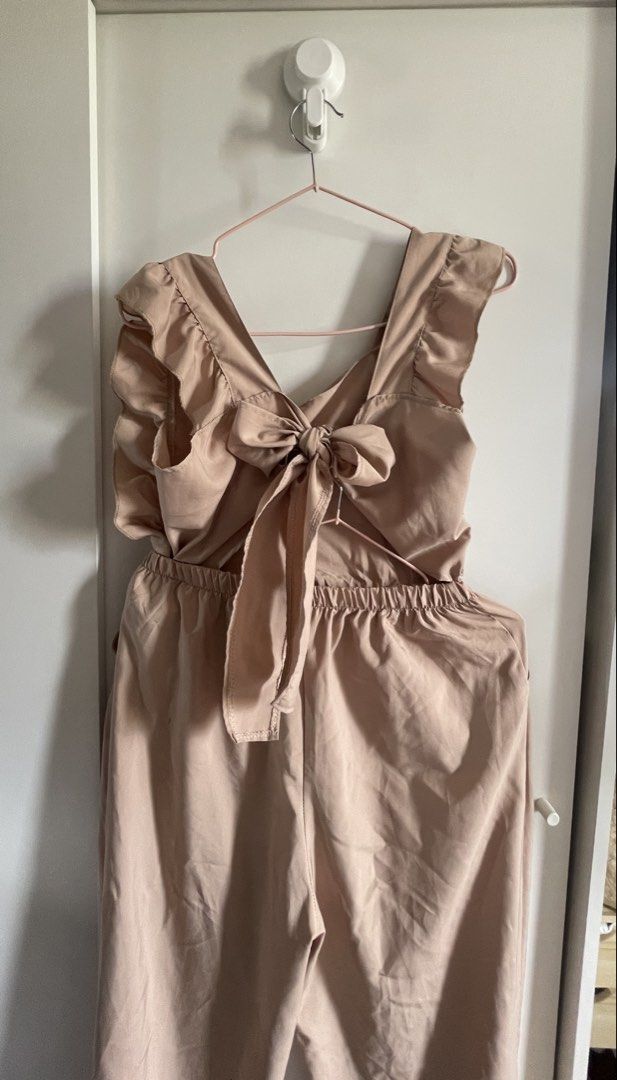 Nude Ruffle Jumpsuit with Bow Back (Category: Jumpsuits) located in Agdangan. Submitted by happyphoenix.d92869 (Listing ID 1469214375, Image 3). Description: - Color: Nude-pink - Style: Wide-leg jumpsuit with easy slip-on design - Details: Cute ruffle shoulder straps and sweet back tie-bow with open cutout - Comfort: Elastic waistband for all-day wear - Practicality: Features functional side pockets - Fabric: Lightweight and breathable, perfect f