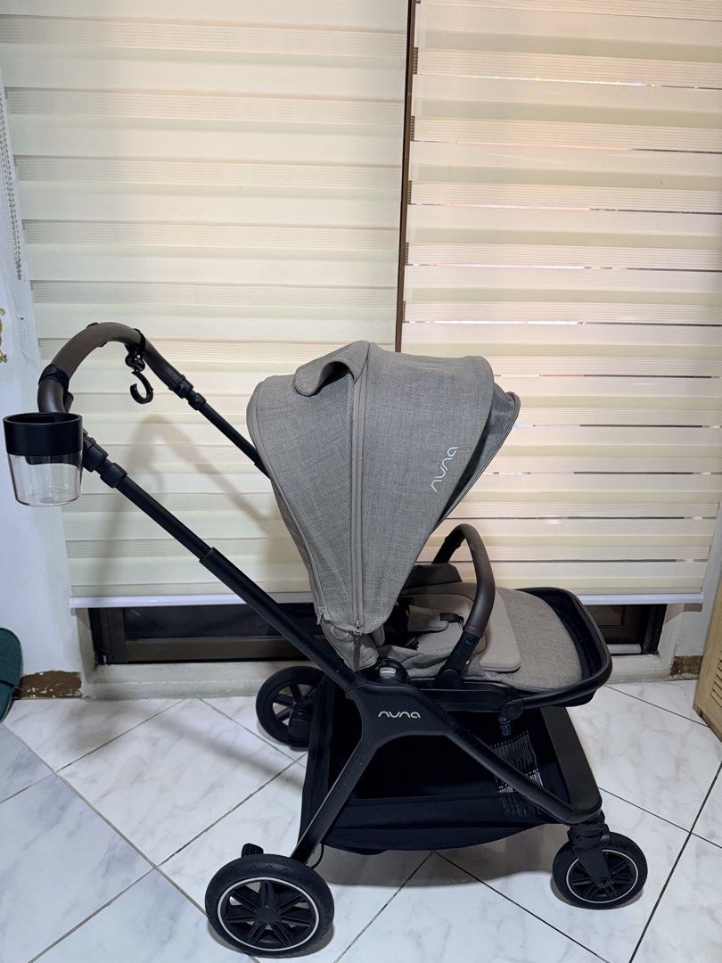 Nuna triv next stroller with nuna cup holder (Category: Strollers) located in Muntinlupa City. Submitted by monicanayve06 (Listing ID 1469199358, Image 1). Description: - Brand: Nuna baby stroller - Color/Design: Chic grey fabric, black frame, and premium brown leather-look handle - Comfort & Safety: Adjustable large canopy for sun protection and a secure safety harness - Convenience: Includes a side-attached cup holder and a spacious under-seat 