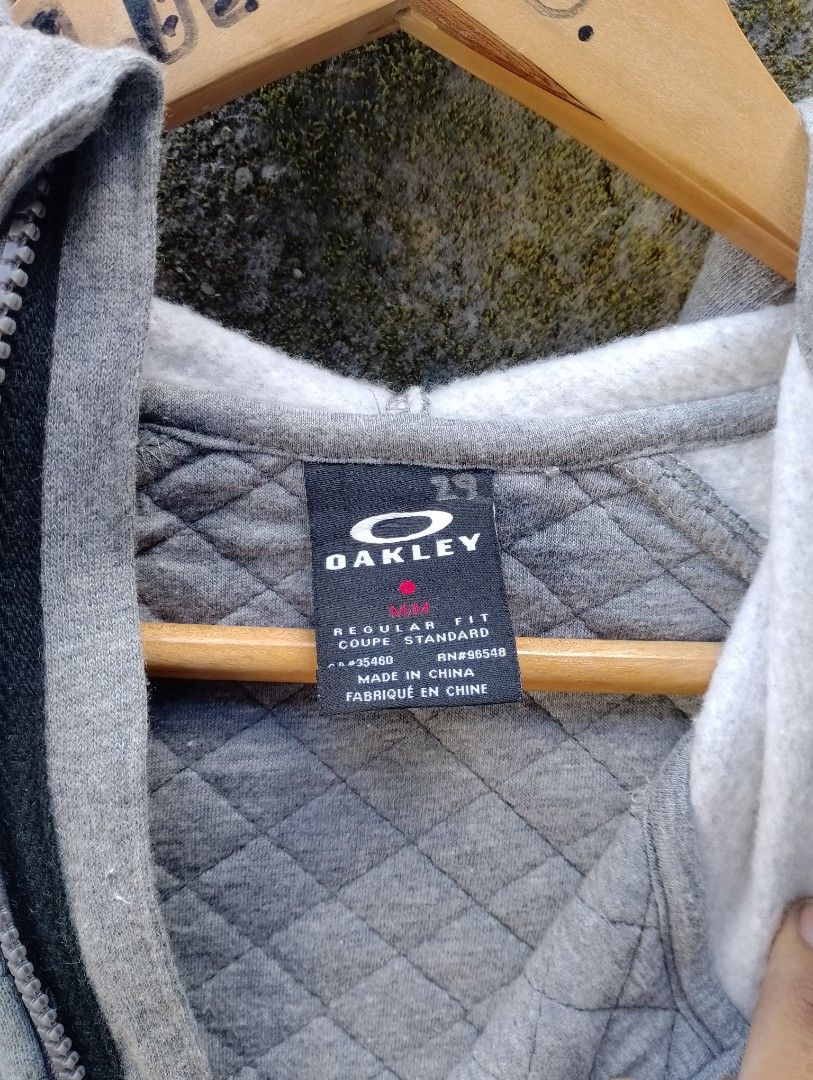 Oakley Quilted Full Zip Hoodie Grey Medium (Category: Coats, Jackets and Outerwear) located in San Ildefonso. Submitted by lanz_baesa (Listing ID 1469318052, Image 2). Description: - Brand: Oakley - Type: Zip hoodie with attached hood - Size: Medium (Regular fit) - Color: Grey - Material: Comfortable cotton and polyester blend - Design details: Quilted pattern on the front and a subtle leather logo patch near the hem - Condition: Good, ideal for 