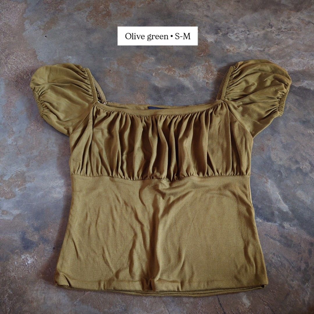 Olive Green Square Neck Ruched Puff Sleeve Top (Category: Blouses) located in Diffun. Submitted by declutteredbyJill (Listing ID 1469236109, Image 1). Description: - Color: Olive green - Design: Square neckline with short puff sleeves and ruched front detail - Fit: Fitted silhouette, best fits sizes S to M - Material: Stretchy, highly comfortable knit fabric - Condition: Clean and ready to wear.