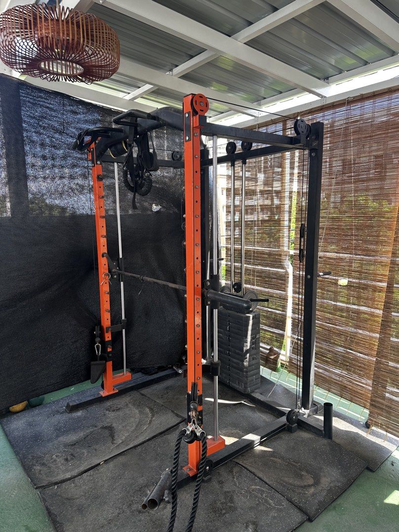 Orange and Black Smith Machine Power Cage with Cable Crossover (Category: Cardio & Fitness Machines) located in Pasig City. Submitted by hernandez2001 (Listing ID 1469273419, Image 3). Description: Complete home gym setup featuring a Smith machine, dual cable pulley, and pull-up bar. Heavy-duty orange and black steel frame with rubber flooring mats included. Perfect for full-body workouts. Buyer must dismantle upon pickup. PM for details!.