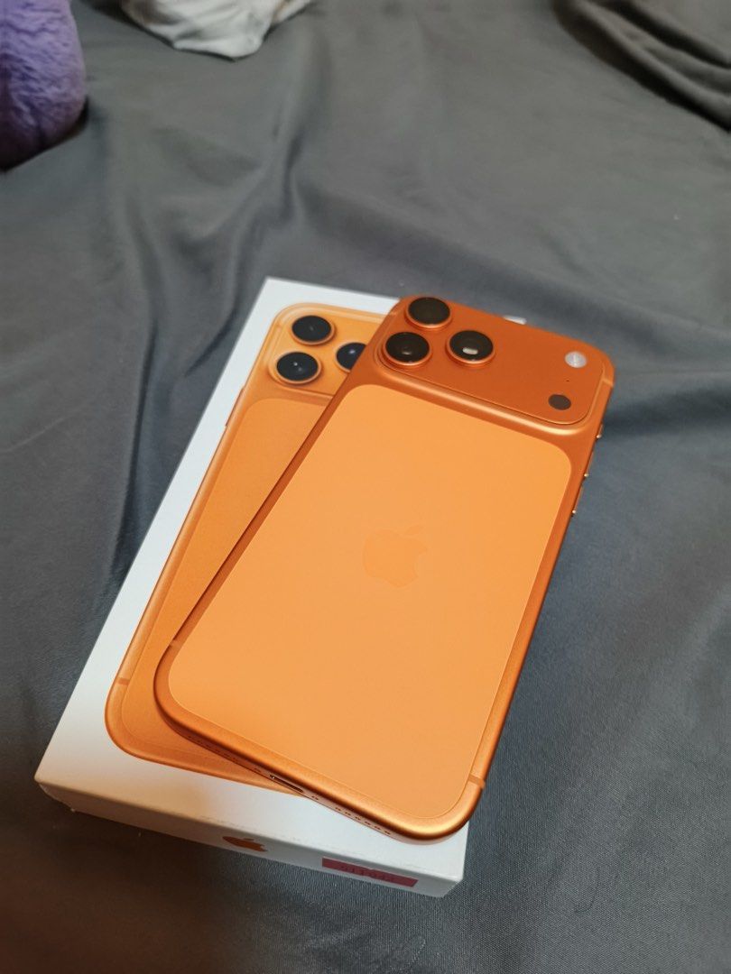 Orange Smartphone with Box and Green Case (Category: iPhone 17 Series) located in Muntinlupa City. Submitted by cloude3 (Listing ID 1469205815, Image 3). Description: iPhone 17 Pro Max 256GB Cosmic Orange No issue 100% Smooth With screen protector and case since day 1 100% Battery Never been repaired Purchased from PowerMac Includes original box and contents RFS: Upgrading.