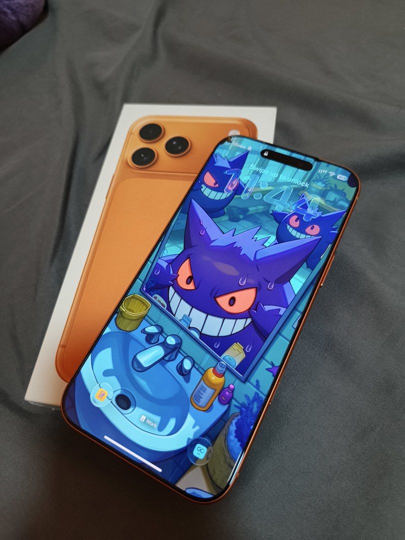 Orange Smartphone with Box and Green Case (Category: iPhone 17 Series) located in Muntinlupa City. Submitted by cloude3 (Listing ID 1469205815, Image 2). Description: iPhone 17 Pro Max 256GB Cosmic Orange No issue 100% Smooth With screen protector and case since day 1 100% Battery Never been repaired Purchased from PowerMac Includes original box and contents RFS: Upgrading.