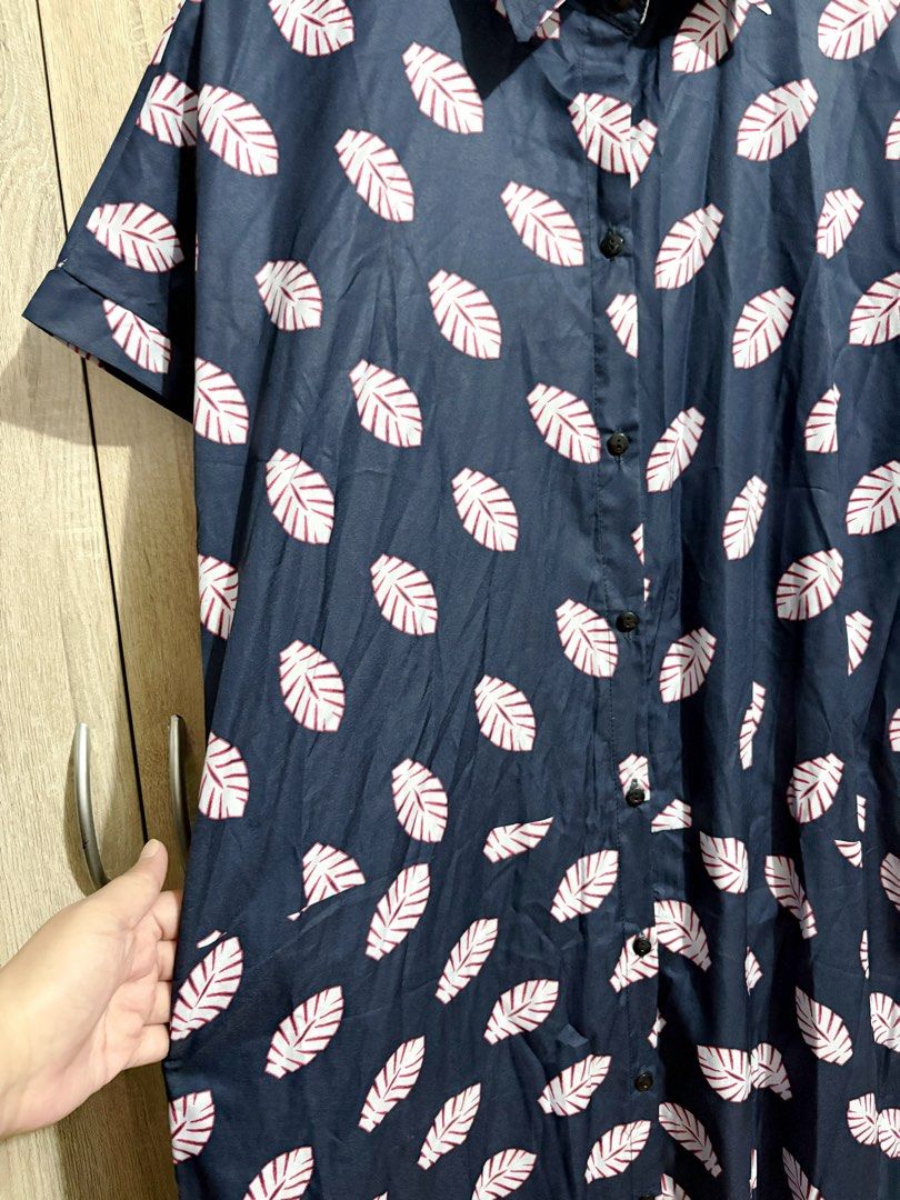 Oversized / Plus Size Navy Blue Leaf Print Button Down Midi Dress (Category: Dresses) located in Manila. Submitted by topsh0ppe (Listing ID 1469215332, Image 2). Description: - Color & Print: Navy blue with an all-over white leaf print and a vibrant mandala pattern on the lower back hem - Design: Short sleeves, lapel collar, and front button-down closure - Material: Lightweight, breathable fabric perfect for effortless everyday styling - Fit & St