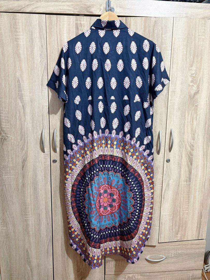 Oversized / Plus Size Navy Blue Leaf Print Button Down Midi Dress (Category: Dresses) located in Manila. Submitted by topsh0ppe (Listing ID 1469215332, Image 3). Description: - Color & Print: Navy blue with an all-over white leaf print and a vibrant mandala pattern on the lower back hem - Design: Short sleeves, lapel collar, and front button-down closure - Material: Lightweight, breathable fabric perfect for effortless everyday styling - Fit & St