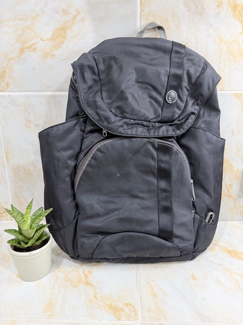Pacsafe anti-theft black backpack (Category: Backpacks) located in Manila. Submitted by haveago0dthrift (Listing ID 1469281374, Image 1). Description: Black Pacsafe backpack with security features. Main flap closure with buckle, front zip pocket, side pockets. Adjustable shoulder straps with clip attachment on one strap. Beige interior lining with multiple organizer compartments and tag. Durable material handles daily commute or travel securely. 