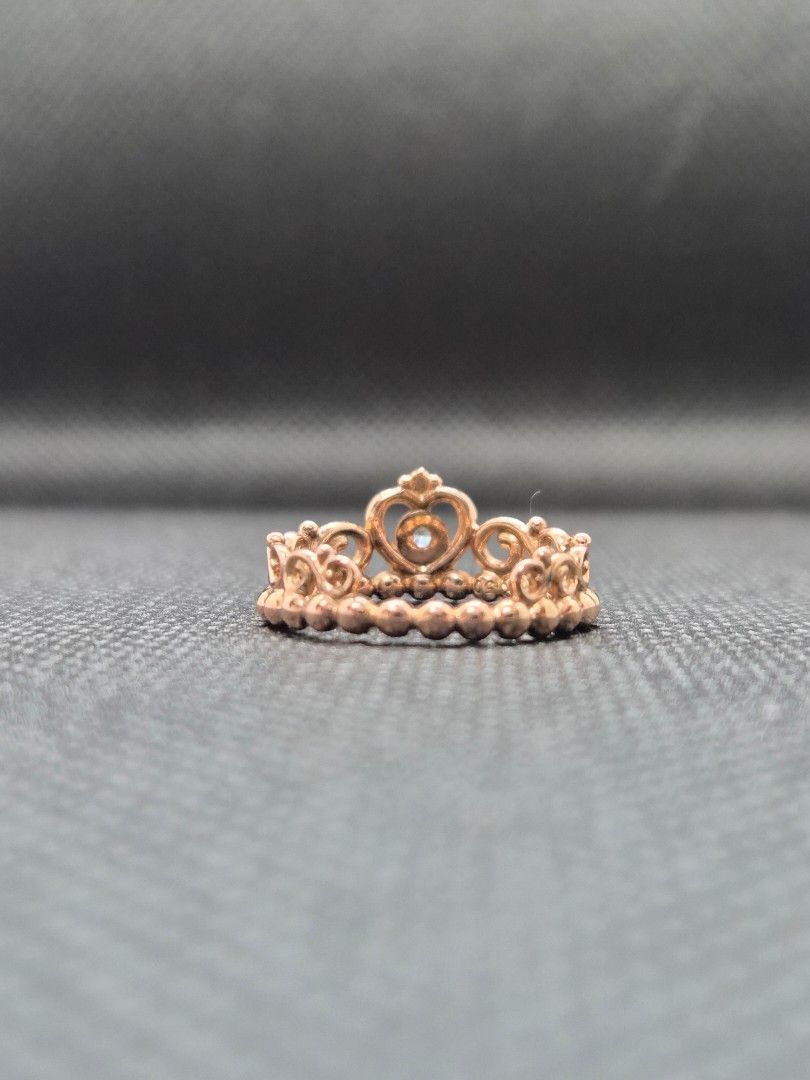 Pandora Rose Gold Princess Crown Ring with Box (Category: Rings) located in Manila. Submitted by prelovedbyc.hannah (Listing ID 1469332191, Image 3). Description: - Brand: Pandora - Material: Rose gold finish - Size: European size 50/ US 5.25-5.5/ 50mm - Design: Princess tiara/crown style with intricate scrollwork and a small clear stone center - Styling: Great for stacking or wearing solo - Inclusions: Original white Pandora box with black velve