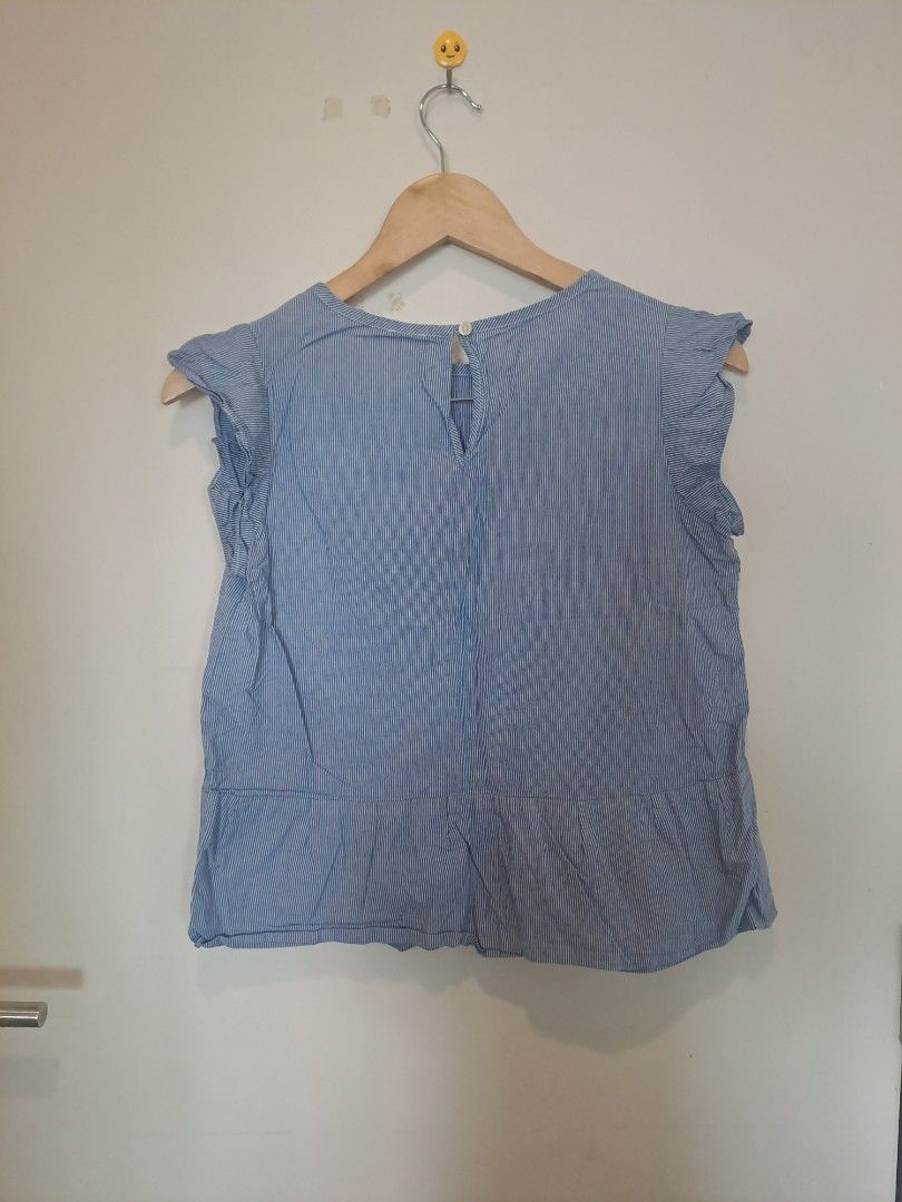 Peplum pinstripe sleeveless (Category: Sleeveless) located in Manila. Submitted by joanbalde39643 (Listing ID 1469205008, Image 2). Description: This item is a blue and white fine-striped peplum blouse featuring short, ruffled flutter sleeves and a classic crew neckline with a keyhole button closure at the back. It is styled with a subtle, flared peplum hem that offers a breezy and feminine silhouette, perfect for warm-weather casual wear.