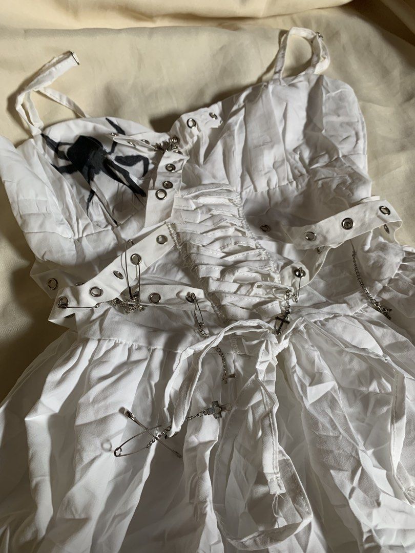Perfect hallowen mini dress (Category: Dresses) located in Davao. Submitted by cheineebau09680 (Listing ID 1469259026, Image 2). Description: - Style: Edgy alternative aesthetic - Design: White mini dress with black spider & flame graphics - Details: Corset-style lace-up back, grommet straps, safety pins, & dangling cross chain - Fit: Size S with adjustable spaghetti straps - Material: 100% polyester (Hand wash only).