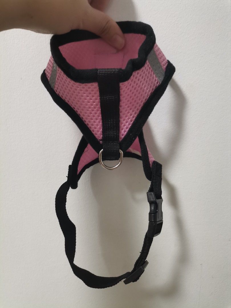 Pink Mesh Pet Harness Size S (Category: Sleeveless) located in Makati City. Submitted by kookybearsstuff (Listing ID 1469278754, Image 2). Description: - Color: Pink with black trim - Size: S (tag attached) - Material: Breathable mesh - Safety: Reflective strips on the sides for night walks - Hardware: Sturdy metal D-ring for leash attachment - Closure: Secure plastic buckle - Details: Adorable paw print badge on the front.