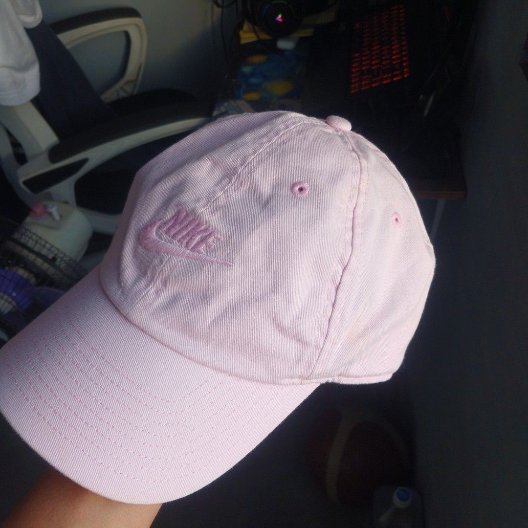 Pink Nike Cap Hat Adjustable Strap (Category: Caps & Hats) located in Manila. Submitted by joefrey12 (Listing ID 1469246606, Image 3). Description: Light pink Nike baseball cap. Classic curved brim and embroidered Nike logo on the front. Adjustable strap in the back with a metal clasp. Inside sweatband shows some discoloration from regular wear. Fabric tag inside lists cotton and polyester materials. Great everyday casual hat..