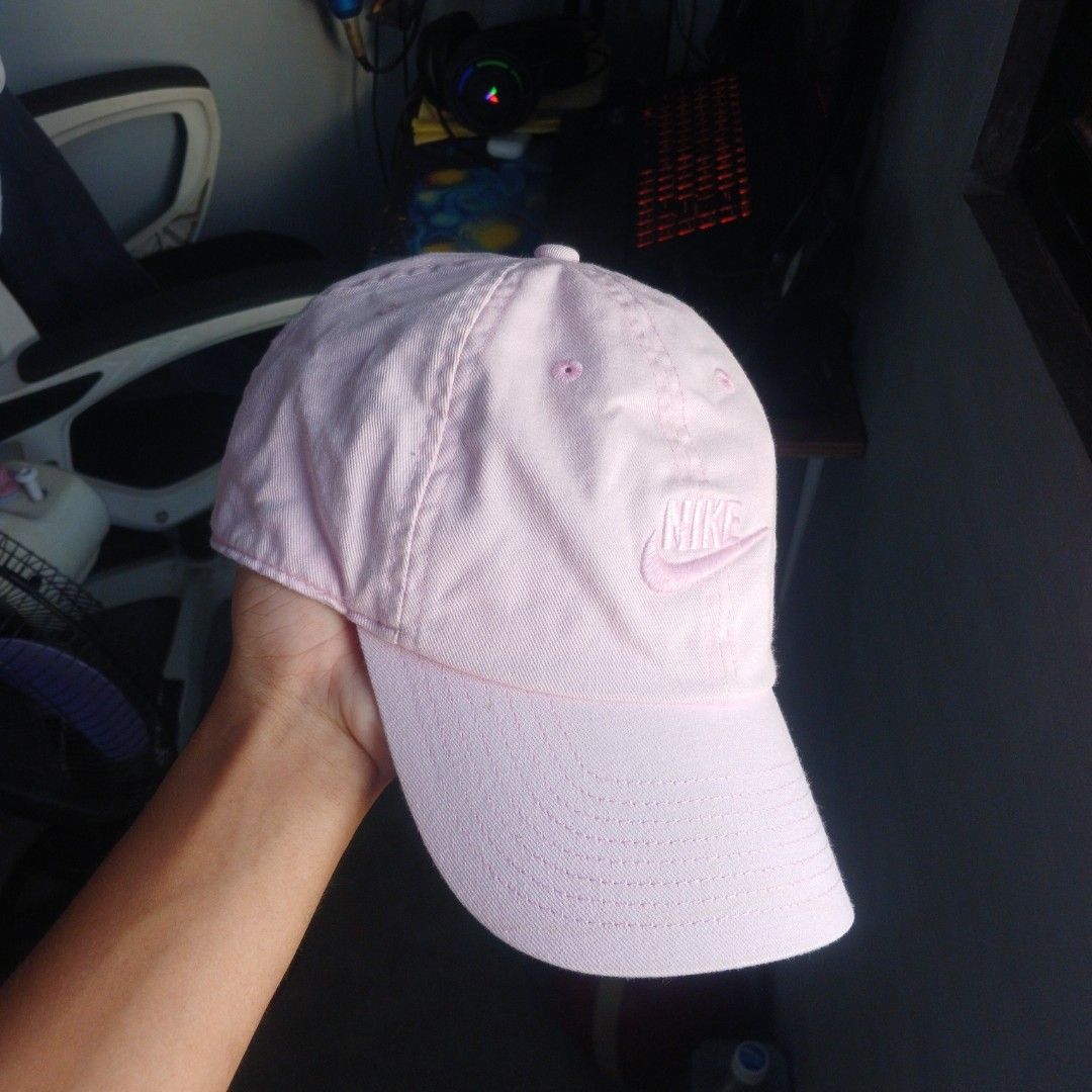 Pink Nike Cap Hat Adjustable Strap (Category: Caps & Hats) located in Manila. Submitted by joefrey12 (Listing ID 1469246606, Image 2). Description: Light pink Nike baseball cap. Classic curved brim and embroidered Nike logo on the front. Adjustable strap in the back with a metal clasp. Inside sweatband shows some discoloration from regular wear. Fabric tag inside lists cotton and polyester materials. Great everyday casual hat..