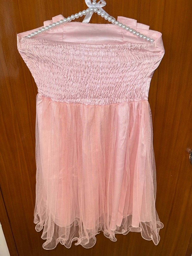 Pink Strapless Tulle Mini Dress With Bow (Category: Dresses) located in Caloocan City. Submitted by prelovedandnewtreasures (Listing ID 1469223456, Image 3). Description: - Color: Light pink - Style: Strapless mini dress (approx. 30 inches long) - Bodice: Satin with a statement front bow and lace accent - Skirt: Fluffy layered tulle with a playful ruffled hem - Fit: Smocked elastic back panel for extra stretch and comfort - Condition: good as new