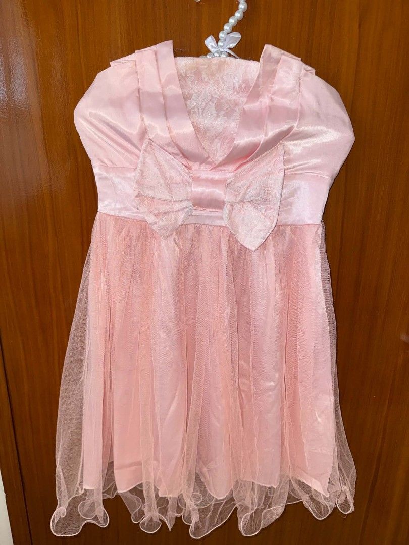 Pink Strapless Tulle Mini Dress With Bow (Category: Dresses) located in Caloocan City. Submitted by prelovedandnewtreasures (Listing ID 1469223456, Image 2). Description: - Color: Light pink - Style: Strapless mini dress (approx. 30 inches long) - Bodice: Satin with a statement front bow and lace accent - Skirt: Fluffy layered tulle with a playful ruffled hem - Fit: Smocked elastic back panel for extra stretch and comfort - Condition: good as new