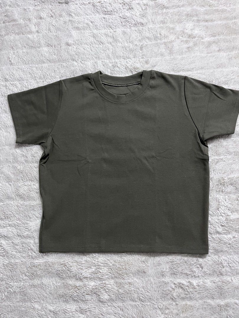 Plain Olive Green Short Sleeve T-Shirt (Category: Shirts) located in Manila. Submitted by kiks_secret_room (Listing ID 1469270197, Image 1). Description: Solid olive green t-shirt with short sleeves and a classic crew neck. Plain front and back design. Clean stitching around the neckline and cuffs. Laid flat, measures roughly 18 inches across the chest and 19 inches in total length. Soft cotton-blend fabric, everyday basic style. Neutral earth to