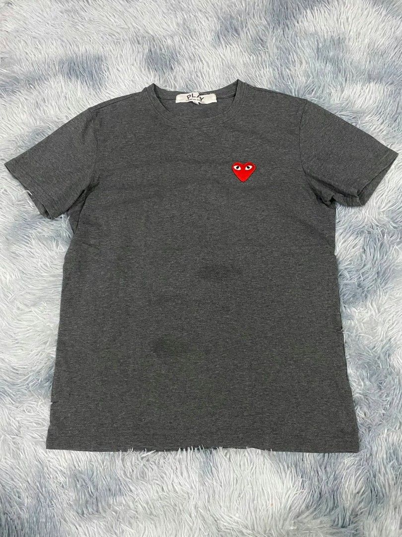 Play Comme des Garcons Dark Grey T-Shirt (Category: Shirts) located in Manila. Submitted by gemfinds650 (Listing ID 1469305802, Image 1). Description: - Brand: Play Comme des Garcons - Color: Dark grey - Design: Iconic embroidered red heart logo on left chest - Fit: Standard fit with short sleeves and crew neck - Condition: Excellent, neck tag intact - Material: Classic comfortable cotton - Styling: Easy to pair with denim or joggers - Shipping o